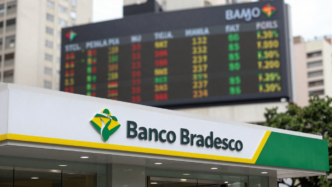 Banco Bradesco branch in São Paulo with a market ticker and Brazilian colors in the background.