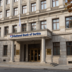 National Bank of Serbia headquarters in Belgrade with a Serbian flag nearby.