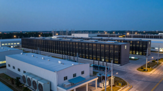 A data center campus connected to electrical grid infrastructure at dusk