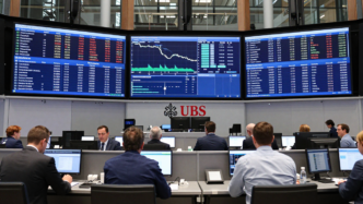 Traders view market screens on a European stock exchange floor.