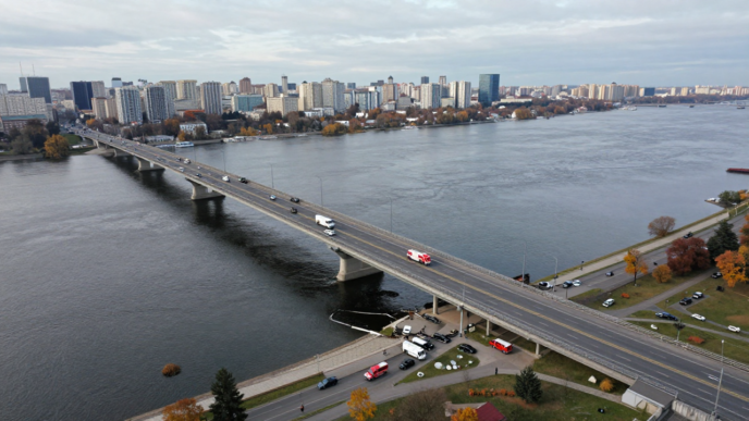 Emergency vehicles near roadway damage on Kyiv’s Northern Bridge over the Dnipro River.