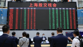 Traders watch market screens in Shanghai as mainland Chinese markets reopen after Golden Week.