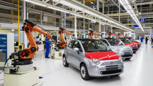 Fiat 500 hybrid cars moving along an automotive assembly line in an Italian factory.