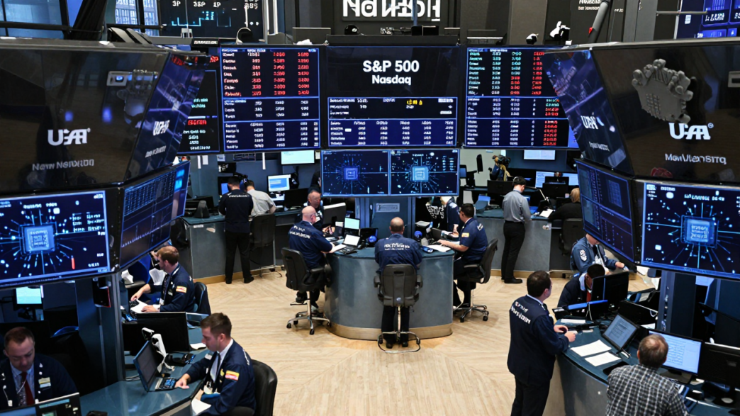 Traders on a U.S. stock exchange floor beneath electronic market boards