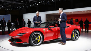 John Elkann and Jony Ive beside Ferrari’s Luce electric car at a Turin conference.