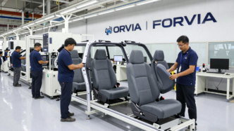 Technicians inspect automotive seat frames and finished seats on a modern production line.