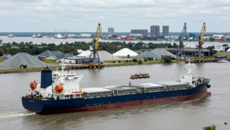 A bulk cargo ship carrying fertilizer approaches port facilities on the Mississippi River near New Orleans.