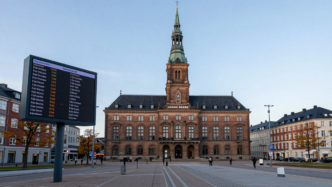 Copenhagen Stock Exchange district with market ticker screens showing Danish shares