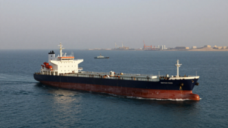 Commercial tanker sailing off Qatar with a patrol vessel nearby