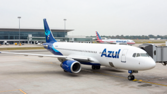 Azul passenger aircraft at a Brazilian airport, with an American Airlines plane in the background.