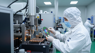 Cleanroom engineer inspecting a silicon wafer at a semiconductor fabrication facility.