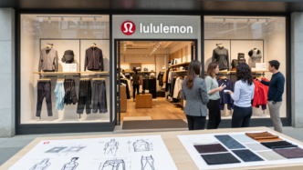 Activewear displayed in a lululemon store with a design team reviewing garments.