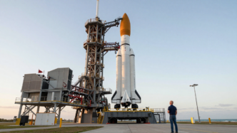 A Blue Origin New Glenn rocket on its Florida launch pad with Jeff Bezos observing nearby.