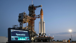 A Falcon 9 rocket on its launch pad beside a display labeled SpaceXSI