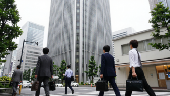 Commuters walk through Tokyo’s business district on a weekday morning.