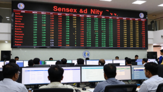 Mumbai traders monitor Indian stock indexes on screens after the RBI rate hike.