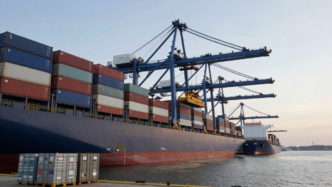 Cargo containers and an industrial freight ship at a U.S. port.