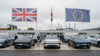 New electric and hybrid cars on a British dealership forecourt amid UK-EU automotive trade tensions.