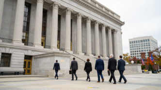 Community bankers carrying legal folders approach a federal courthouse in Washington, D.C.